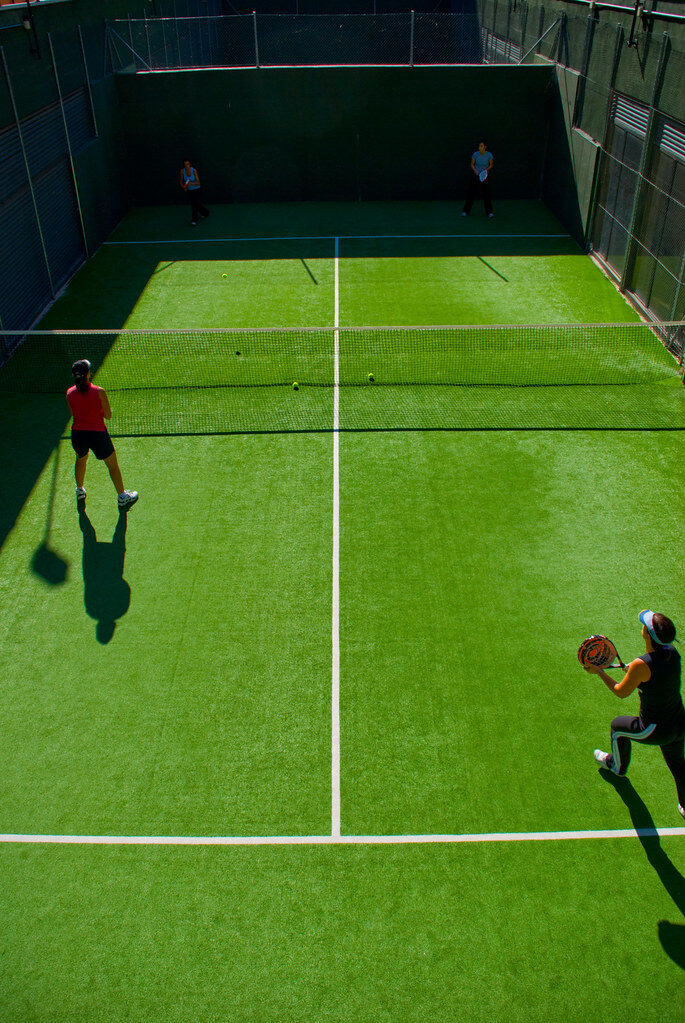Padel doubles on a glass-walled court